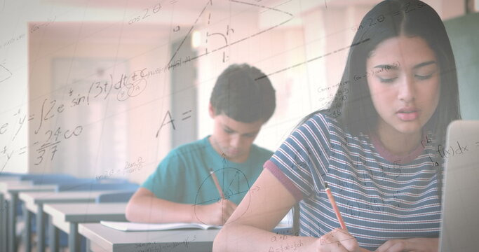 Image of mathematical equations over schoolgirl using laptop in classroom