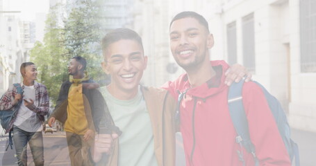 Composite of happy mixed race male friends talking in street, and embracing wearing backpacks