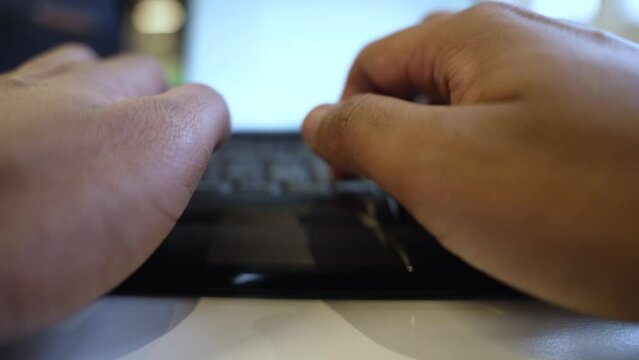 Hands typingon a laptop, blurred background, close-up, indoor setting