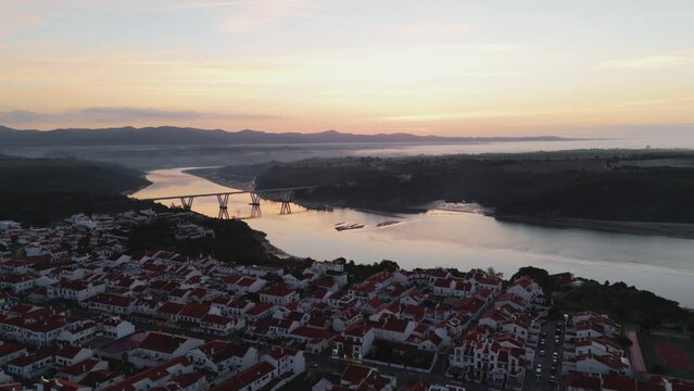 Sunrise View Of Road Bridge Over River Mira In The Town Of Vila Nova de Milfontes, Alentejo, Portugal. aerial pullback shot - Powered by Adobe