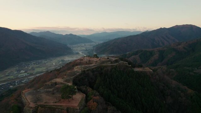 Aerial Japanese Mountain Range Valley in Takeda Castle ruins Asago Hyogo Deep Mountain Range with Sunset Skyline, gradient, aerial drone establishing Japan Travel