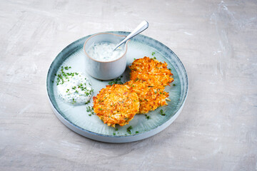 Traditional parsnip potato pancakes with chives and quark dip served as close-up on a Nordic Design...