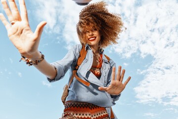 Happy Traveler's Dance: Smiling Woman with Backpack Enjoying Freedom and Natural Beauty on a Beach
