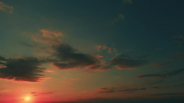 Golden Clouds In Blue-Green Evening Sky. Orange Light Shining Against Fluffy Black Clouds.