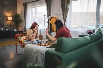 two women young females sisters friends play chess board game at home