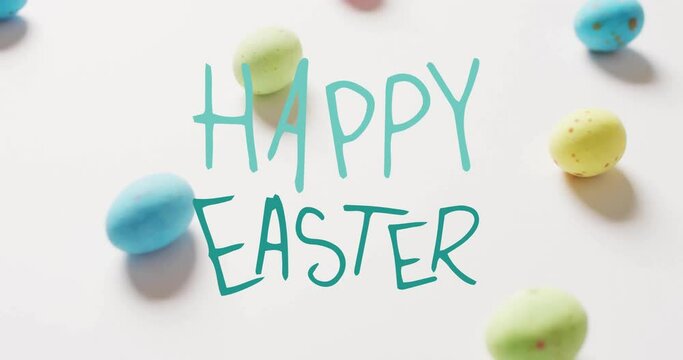 Animation of happy easter text over colourful eggs on white background