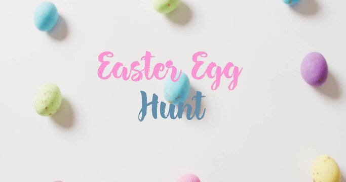 Animation of easter egg hunt text over colourful easter eggs on white background