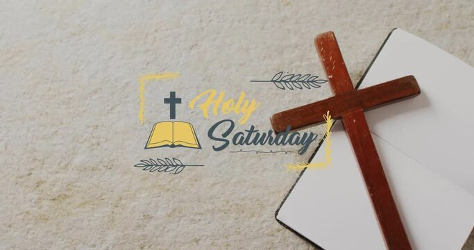 Animation of holy saturday text over christian cross and book on grey background