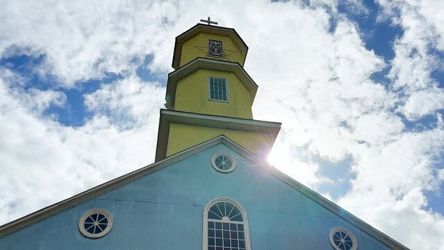 Looking Up At Yellow Tower Of Historic Blue Patrimonial Church, Chonchi, Chiloe Chile