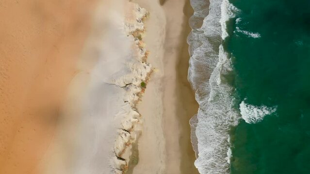 Aerial view of the sea, waves and the cliffs of Morro Branco, Ceara, Brazil