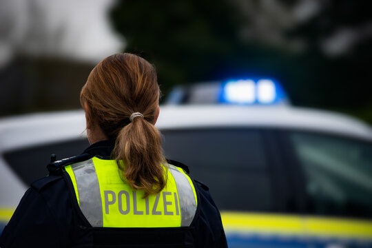 Deutsche Polizistin vor einem Streifenwagen
