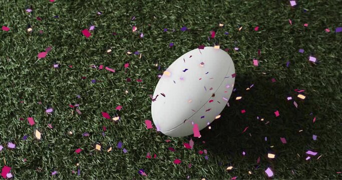 Animation of confetti over white rugby ball on grass