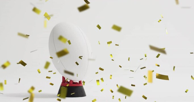 Animation of confetti over white rugby ball on white background