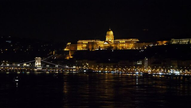 Budapest city (Hungary capital) center view with Buda Castle and Danube river at night, gothic architecture, light reflections, wide panoramic shot