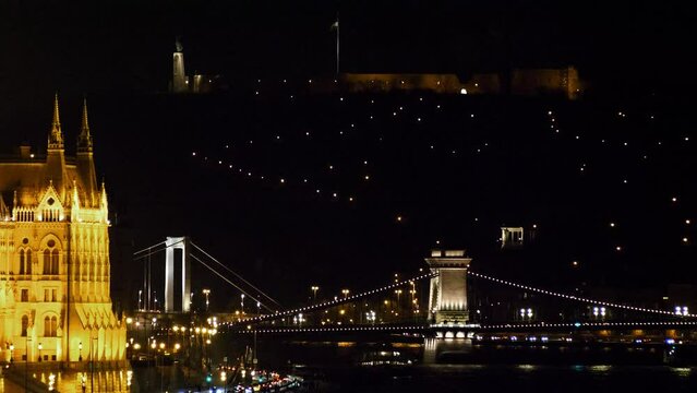 Budapest city (Hungary capital) center view with illuminated Erzs&eacute;bet Bridge and Danube river at night, gothic architecture, light reflections, distant medium shot