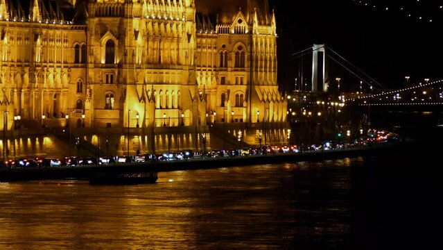 Budapest city (Hungary capital) center view with Parliament building and Danube river at night, gothic architecture, light reflections, distant panoramic shot