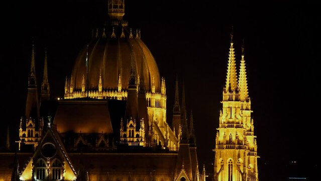 Budapest city (Hungary capital) center view with Parliament building and Danube river at night, gothic architecture, light reflections, medium shot with towers