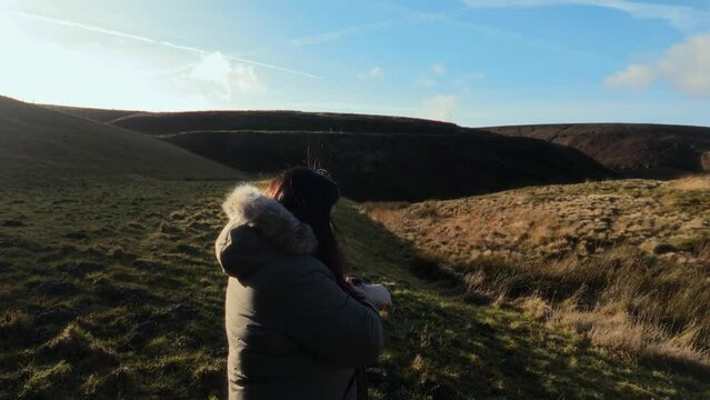 Young boy and his mother walking on a rural footpath on a day out in the country. Countryside activity scene with moorlands and a large lake