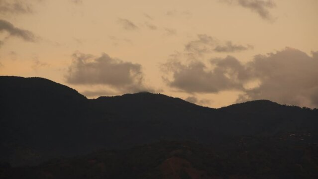 Timelapse footage of the clouds moving over the mountains at sunset in Kingston, Jamaica