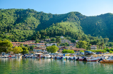 Fototapeta na wymiar Small town harbor with boats on water in Thassos, Greece