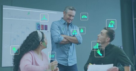 Animation of ecology icons over diverse colleagues discussing work in office - Powered by Adobe