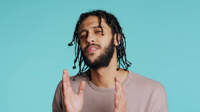Desperate guy asking for forgiveness, putting hands together in imploring gesturing, showing regret emotion. Upset man saying sorry, begging for apology, feeling guilty, studio background, camera B