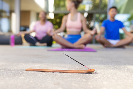 Diverse group practices yoga outdoors, with copy space