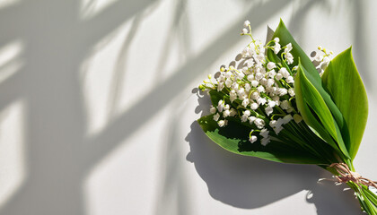 Floral flat lay of bouquet lily of the valley flowers with shadows and copy space