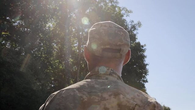 Back view of male soldier leaving on military service. Man in military uniform. Ukrainian Armed Forces. Concept of military service, army, duty
