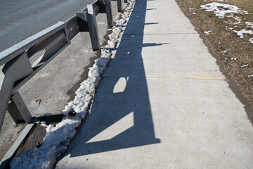 Fototapeta premium guard rail, sidewalk, and grass with shadow