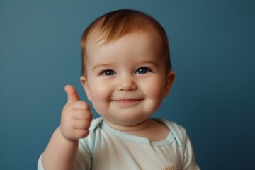 Smiling baby with thumbs up