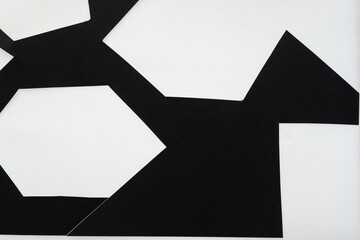 black paper frame with irregular hexagonal shape cutouts on white