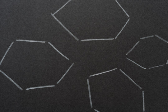 black paper with white lines arranged in loose hexagonal spaces