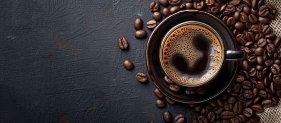 A bold and beautiful cup of black coffee sits on a rustic black background, elegantly blending with the surrounding coffee beans.