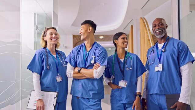 Portrait Of Smiling Multi Cultural Medical Team Wearing Scrubs In Modern Hospital 