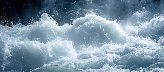 This photo captures the captivating and thrilling sight of a large body of water covered in lots of white foam, caused by the majestic river rapids and the forceful waves spraying water. - obrazy, fototapety, plakaty