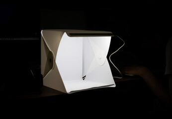 box for product photography illuminating in the middle of the darkness