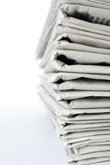 Stack of newspapers on white background, closeup. Journalist's work