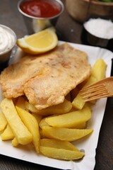 Delicious fish and chips served on table, closeup