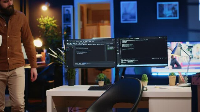 Developer arriving in apartment office with coffee mug in hand, ready to start coding on computer. IT specialist begins teleworking job shift, holding cup of tea, upgrading company software, camera A