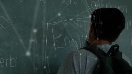 Animation of network of connections over biracial schoolboy writing on chalkboard - Powered by Adobe