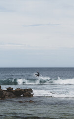 Young surfer doing an aerial turn on a small surfboard in perfect waves
