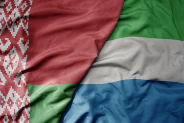 big waving national colorful flag of sierra leone and national flag of belarus.