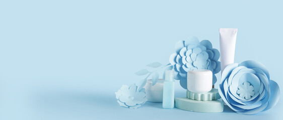 Cosmetic products, paper flowers and leaves on light blue background with space for text