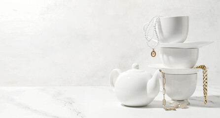 Obraz na płótnie Canvas Tea set with stylish jewelry on light background with space for text