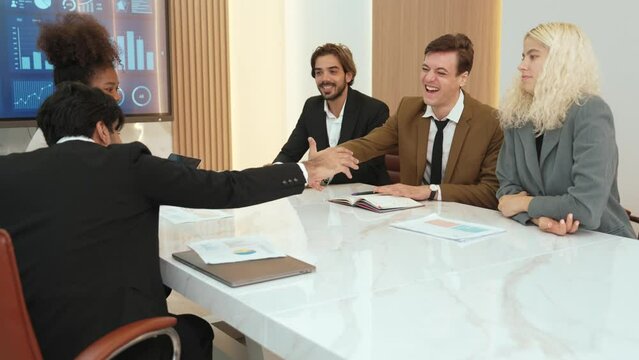 Ornament meeting room with group of diversity business people or office worker college shake hand with TV screen display company's successful marketing plan from hardworking as team.