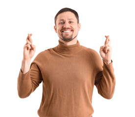 Handsome man crossing fingers on white background