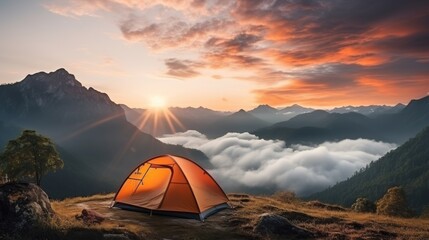 Orange tent camping in the mountains in front of majestic mountain
