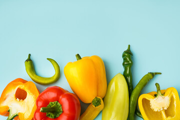Different fresh peppers on blue background