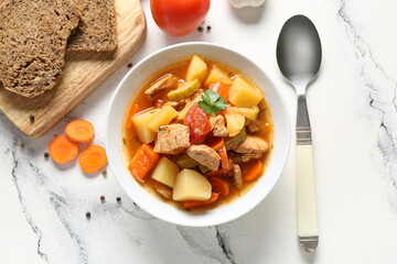 Bowl with delicious beef stew and bread on white background